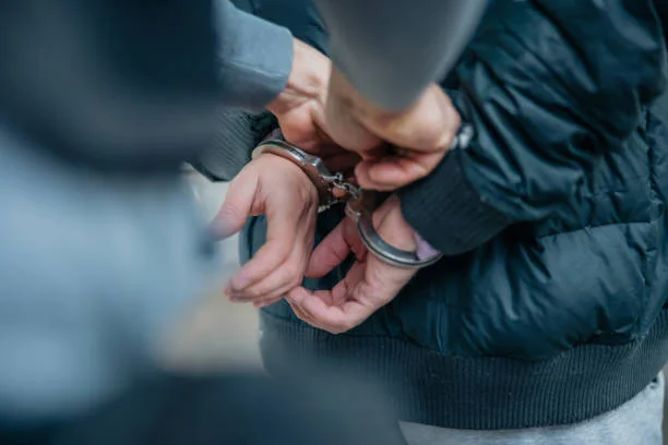 policia-desbloqueando-unas-esposas-en-la-espalda-del-delincuente